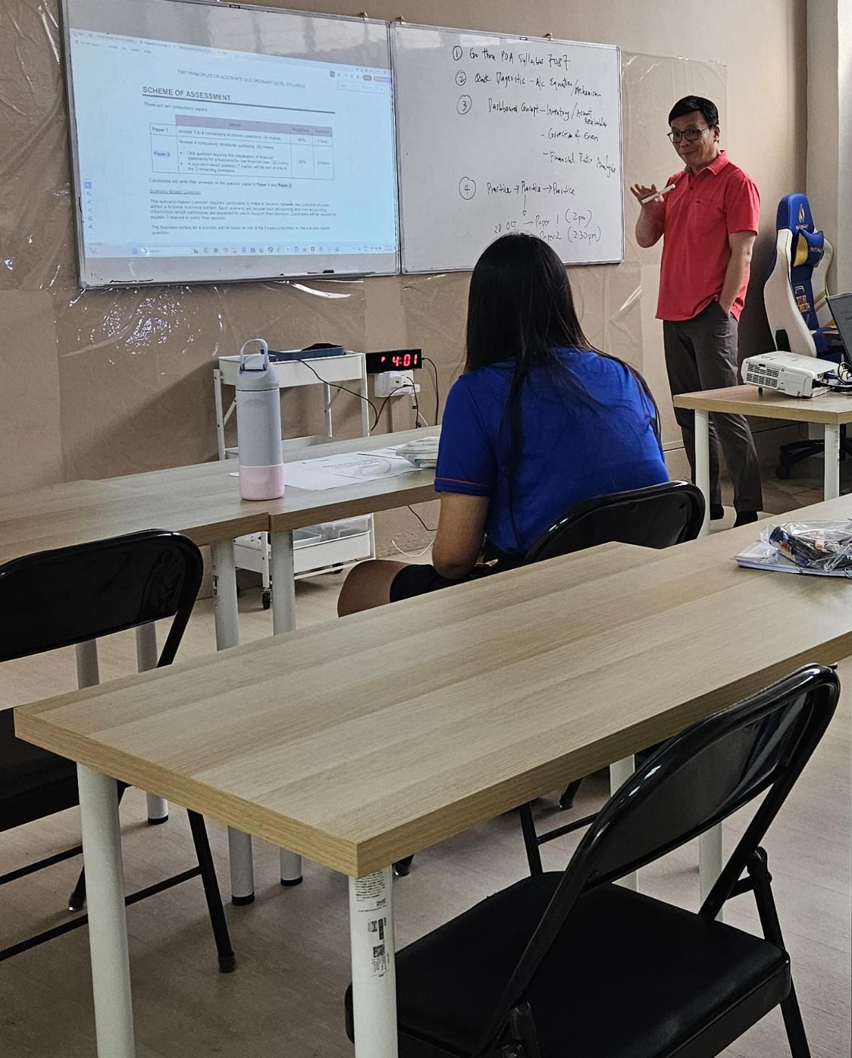 Teacher Lawrence Poh guiding a small-group POA lesson in the Chinatown classroom