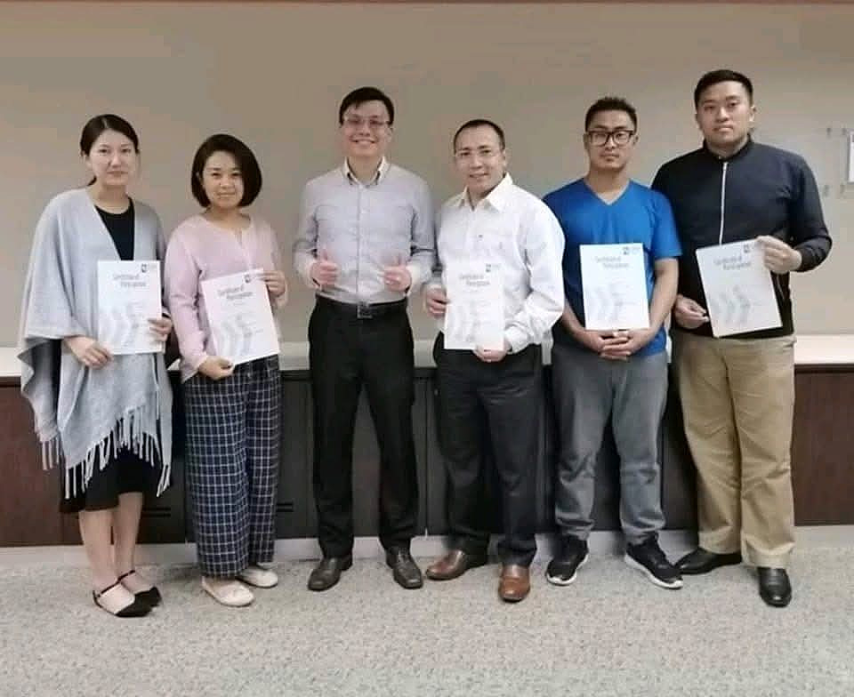 Lawrence Poh with adult course participants holding their certificates